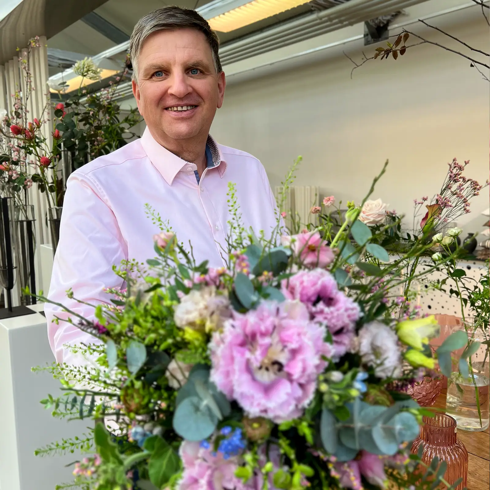 Foto von Andreas Sudeck in einem Blumengeschäft umgeben von Blumen